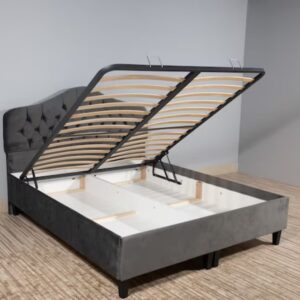 photo bed with gray upholstery, without mattress and with opened storage in an empty room