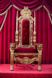 Photo red royal chair on a background of red curtains. place for the king. throne