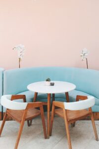 Colorful shot of best craft furniture modern light blue sofa, white wooden table , wooden chairs and white flowers