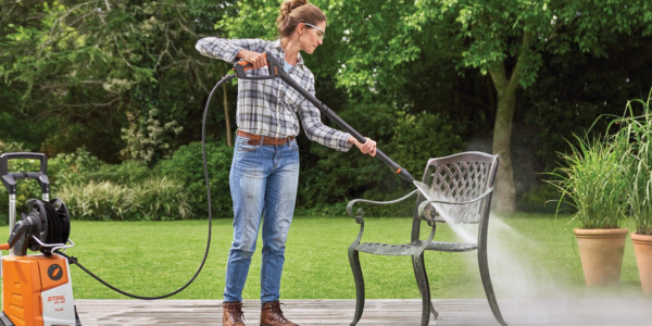 a women cleaning wrought iron patio furniture with pressure gun